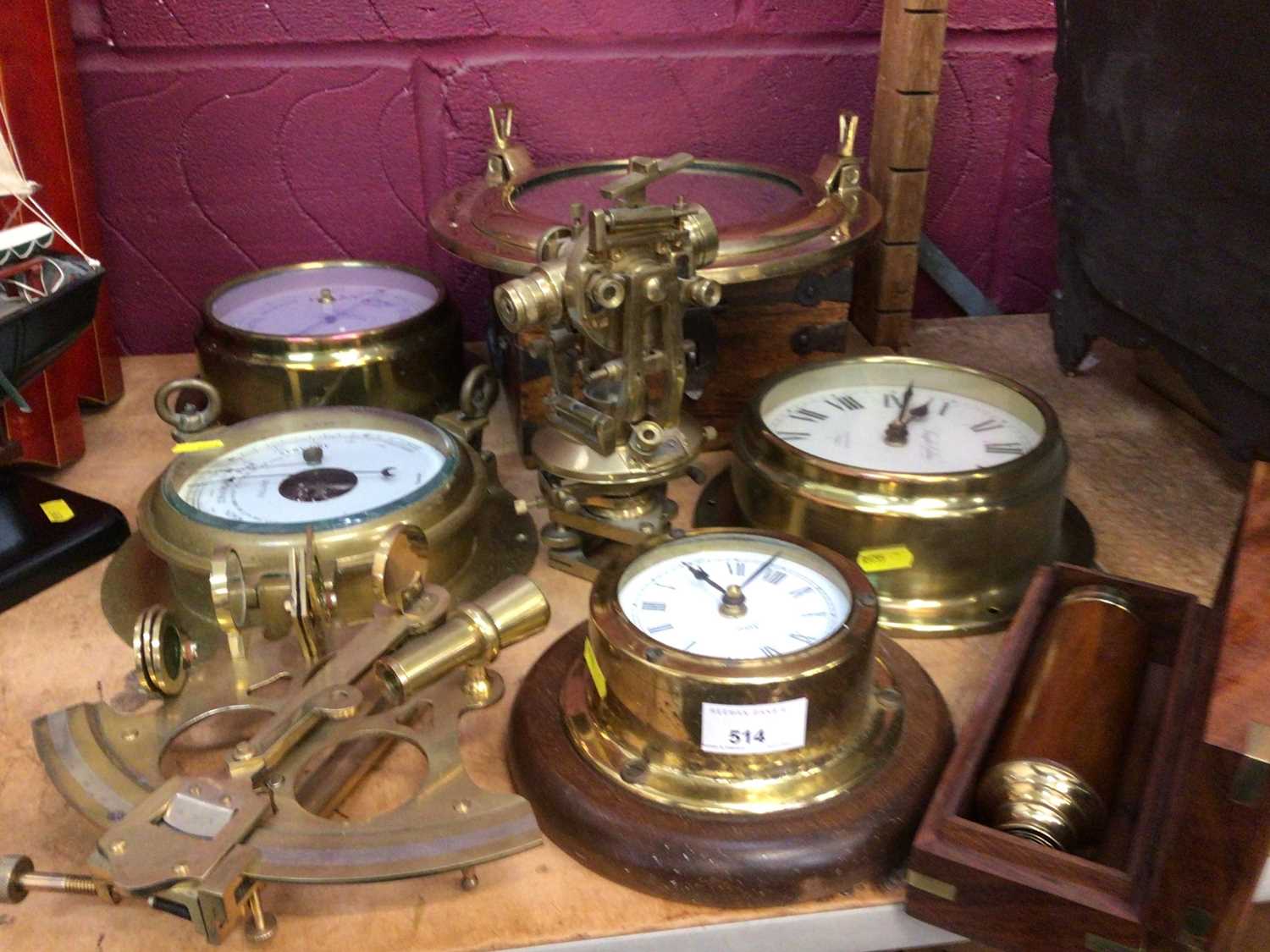 Lot 514 - Selection of nautical brass ware including clocks, barometers, port hole mirror and adjustable scope