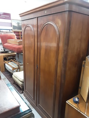 Lot 1017 - Victorian mahogany double wardrobe with two arched panelled doors enclosing hanging space and five graduated drawers, 149cm wide, 58cm deep, 205cm high