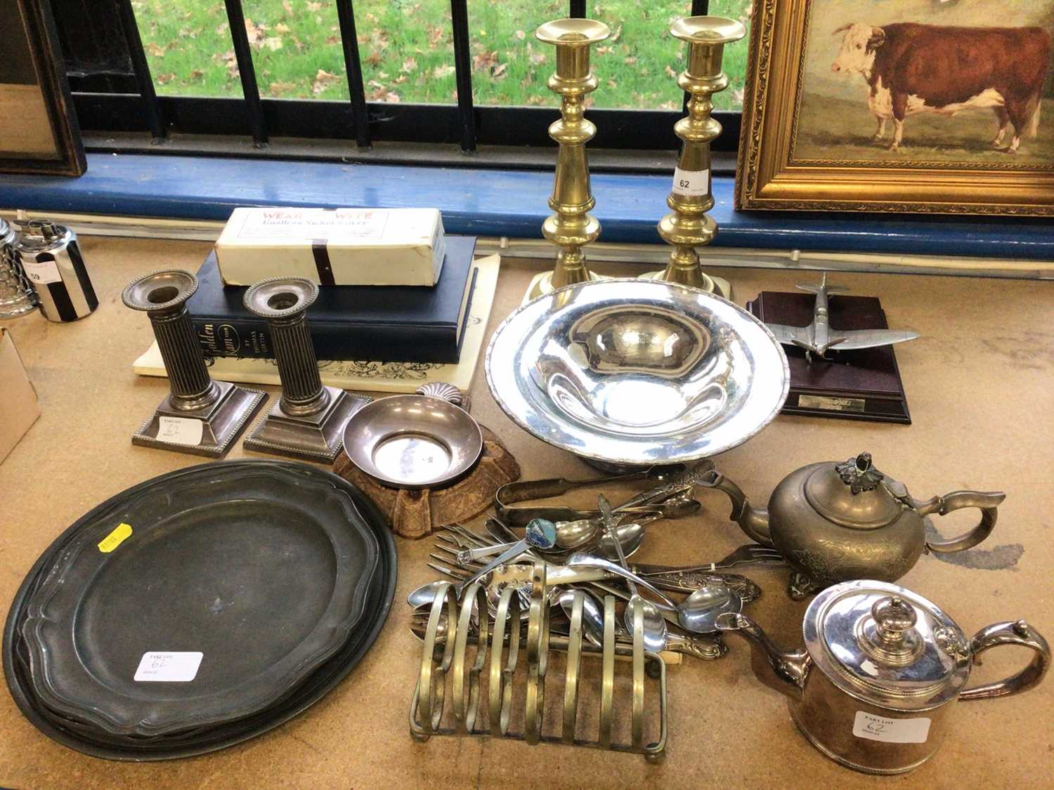 Lot 62 - Three pewter dishes, together with a pair of brass candlesticks and a pair of silver plated candlesticks