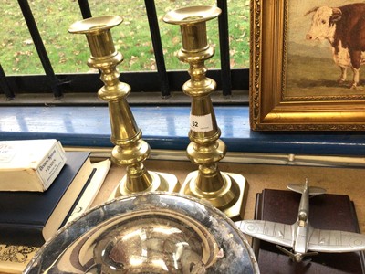 Lot 62 - Three pewter dishes, together with a pair of brass candlesticks and a pair of silver plated candlesticks