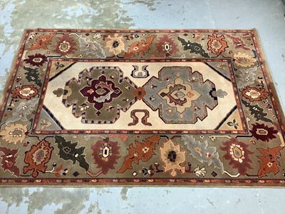 Lot 1069 - Large rug with geometric decoration on beige and green/brown ground, 299cm x 204cm