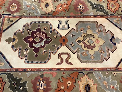 Lot 1069 - Large rug with geometric decoration on beige and green/brown ground, 299cm x 204cm