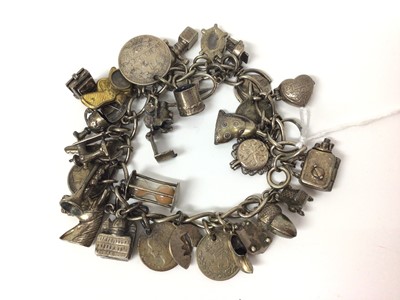 Lot 660 - Silver charm bracelet with a mix of silver, white metal and base metal novelty charms