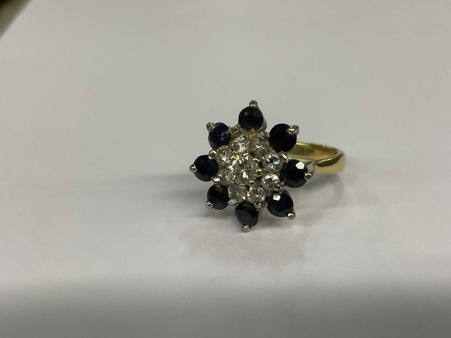 Lot 676 - Diamond and sapphire cluster ring in 18ct gold setting