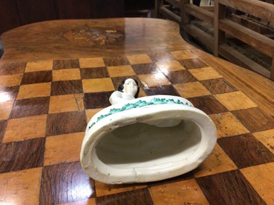 Lot 60 - Unusual Victorian Staffordshire figure of a girl with two rats or mice, the oval base decorated with a foliate pattern