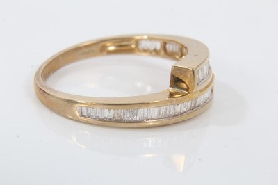 Lot 119 - Diamond crossover ring with channel set baguette cut diamonds in 9ct yellow gold setting