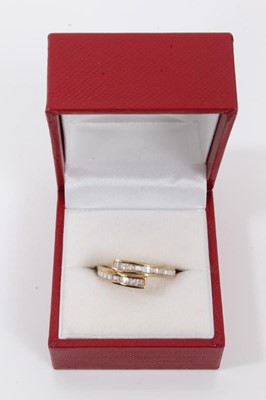 Lot 119 - Diamond crossover ring with channel set baguette cut diamonds in 9ct yellow gold setting