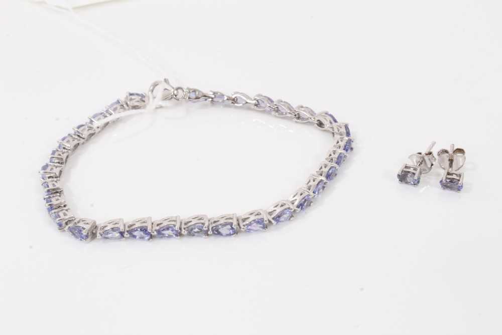 Lot 123 - Tanzanite bracelet with a continuous line of pear cut tanzanites in platinum overlaid silver setting together with a pair similar stud earrings