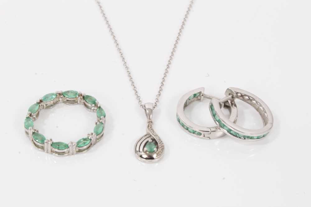 Lot 124 - Emerald and white topaz circular pendant in platinum overlaid silver setting, another similar pendant on chain and a pair of similar hoop earrings.