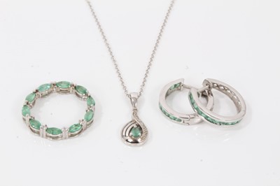 Lot 124 - Emerald and white topaz circular pendant in platinum overlaid silver setting, another similar pendant on chain and a pair of similar hoop earrings.