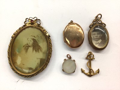 Lot 689 - 9ct gold oval locket, one other glazed locket, 9ct gold anchor charm, 9ct gold mounted mother of pearl charm and a gilt metal brooch containing an old photograph of a girl (5)