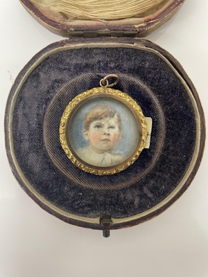 Lot 698 - Antique 9ct gold locket with foliate borders and engraved foliate scroll decoration, containing a portrait miniature of a young boy, named David Wormald (1907-1927), in fitted case