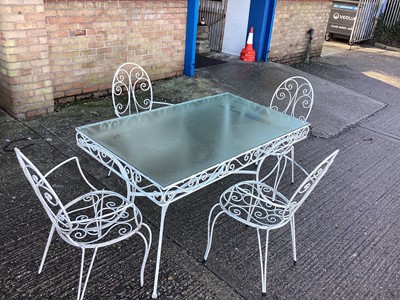 Lot 998 - Wrought iron garden table with glass top and a set of four matching chairs