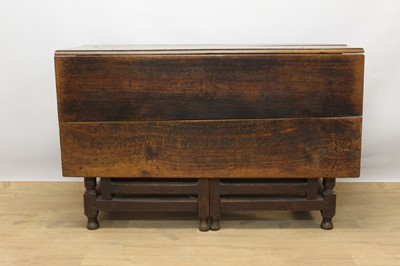 Lot 1322 - 17th century oak drop leaf dining table, with hinged top on gun barrel supports and stretchers, 154 x 119cm