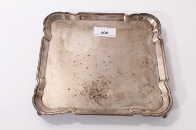 Lot 408 - 1930s silver salver of square form, with piecrust border, on four shaped bracket feet