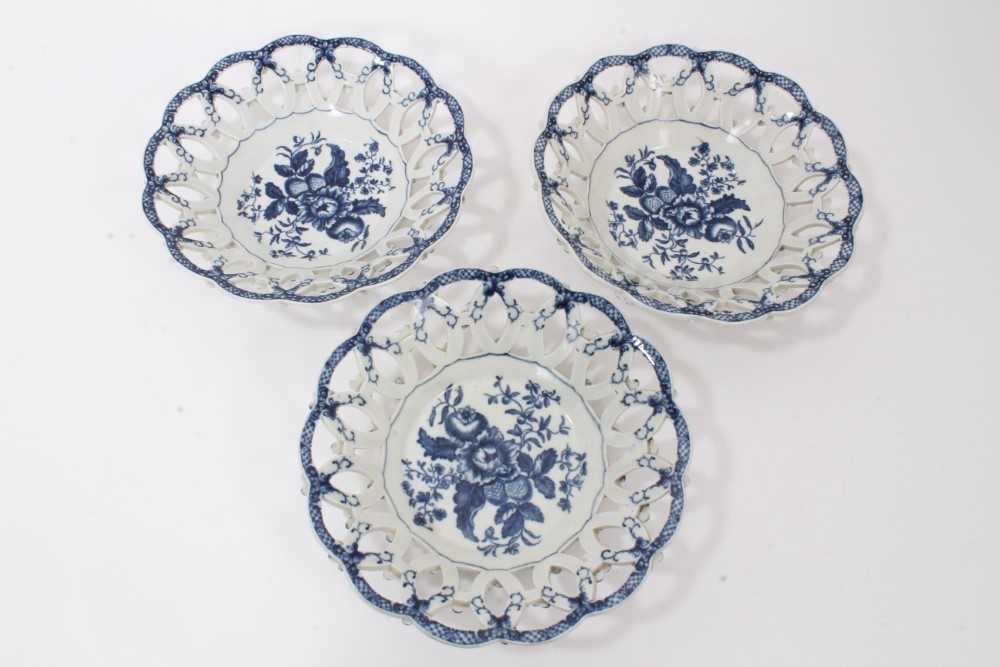 Lot 107 - Three Worcester blue and white Pinecone pattern pierced baskets, circa 1770, the outsides with moulded flowers, two with crescent marks, 21.5cm diameter