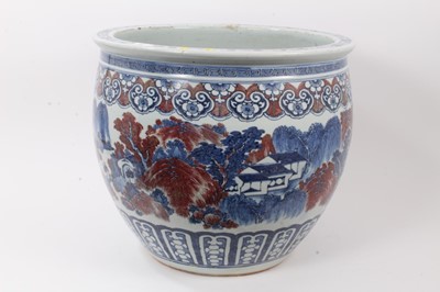 Lot 261 - Large Chinese porcelain fish bowl, 20th century, decorated in underglaze blue and red with landscape scenes and patterned borders