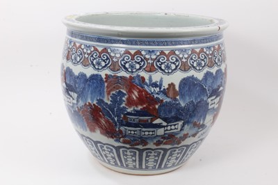 Lot 261 - Large Chinese porcelain fish bowl, 20th century, decorated in underglaze blue and red with landscape scenes and patterned borders