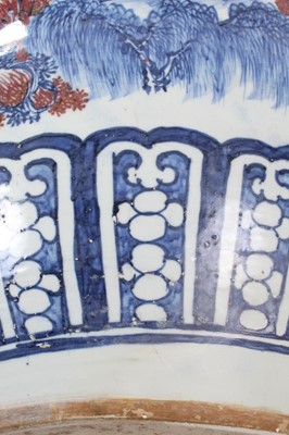 Lot 261 - Large Chinese porcelain fish bowl, 20th century, decorated in underglaze blue and red with landscape scenes and patterned borders