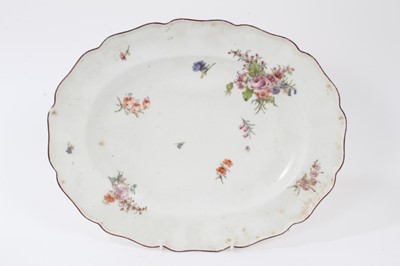 Lot 109 - A Chelsea scalloped oval dish, circa 1755, polychrome painted with floral sprays, brown-painted rim, red anchor mark to base, 32.5cm wide