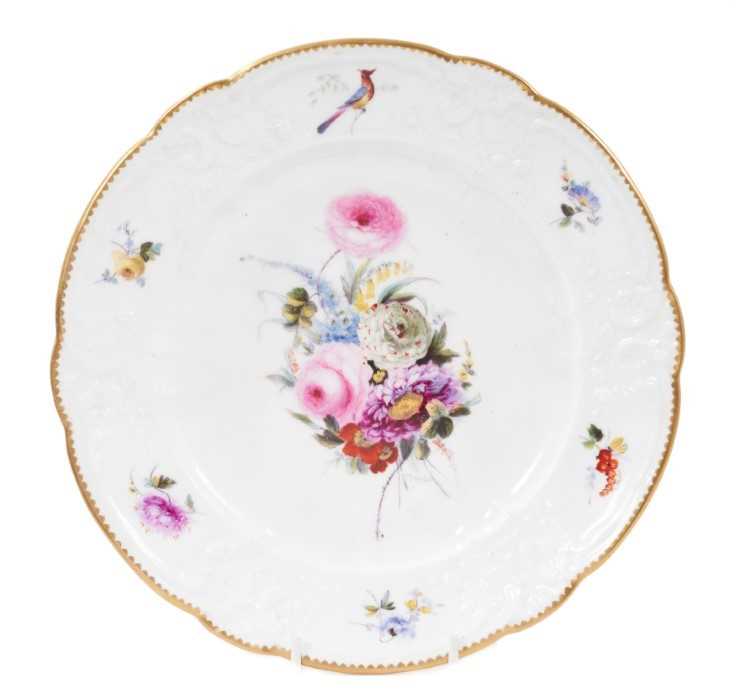 Lot 110 - A Nantgarw porcelain plate, circa 1818-1820, the circular plate with shaped and gilt-painted rim,  floral-moulded rim, polychrome decorated around the edge with a birds and flowers in floral-moulde...