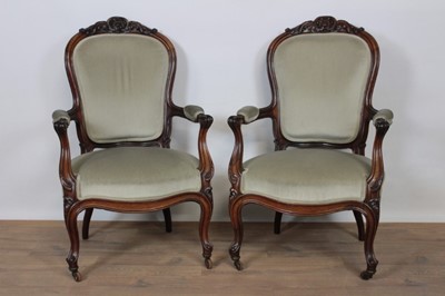 Lot 1350 - Pair of 19th century rosewood open armchairs, with pad back, arms and seat and channel carved showwood frame on cabriole legs and castors