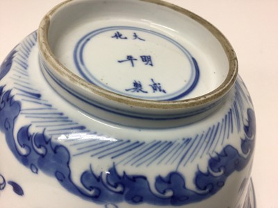 Lot 129 - Fine Chinese blue and white bowl, Kangxi period, of round form with straight foot and flared rim, decorated with dragons chasing flaming pearls, amongst stylised clouds and waves, prunus flowers on...