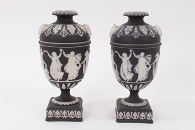 Lot 217 - A pair of Wedgwood black Jasperware urns, decorated in relief with classical figures, 19cm high