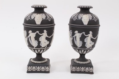 Lot 217 - A pair of Wedgwood black Jasperware urns, decorated in relief with classical figures, 19cm high