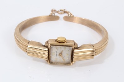 Lot 738 - Ladies Art Deco ‘Odeonesque’ Zenith 9ct gold bangle watch with rectangular dial in gold case on a gold hinged bangle