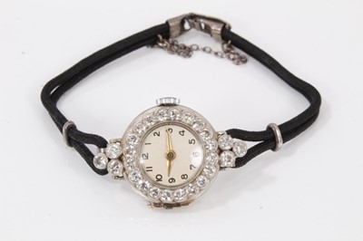 Lot 733 - 1920s ladies diamond and platinum cocktail wristwatch, the circular dial with diamond set bezel and shoulders, all with round old cut diamonds in millegrain setting in platinum case on black double...