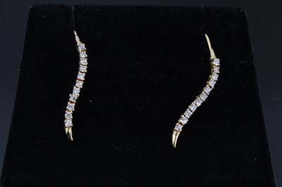 Lot 657 - Pair of diamond earrings, each with a serpentine line of eleven brilliant cut diamonds in gold setting.