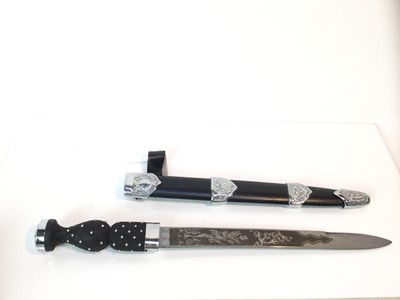 Lot 921 - Elizabeth II Scottish Regimental Piper's Dirk with studded ropework hilt and crown pommel, the etched steel blade with foliate & thistle decoration in black leather scabbard with white metal thistl...