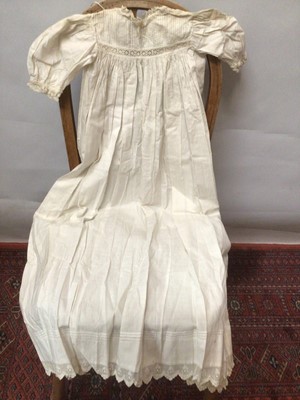Lot 2154 - A selection of Victorian/ Edwardian babies clothing including four caps, three lace and embroidery Christening gowns, two Christening petticoats, also a girl's cut-out work dress and a plain pettic...