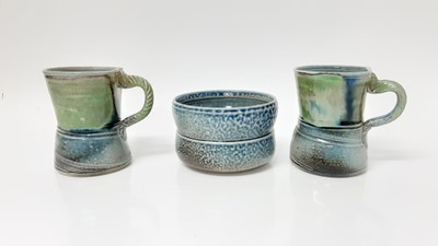 Lot 1194 - Two Jane Hamlyn studio pottery salt glazed mugs, 10cm high, together with a bowl, 11cm diameter (3)