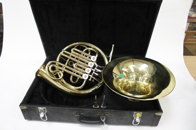 Lot 2321 - Brass French horn with detachable bell and two mouthpieces, cased