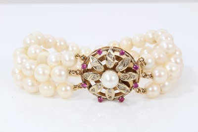 Lot 323 - Three strand cultured pearl bracelet with gold gem set flower clasp