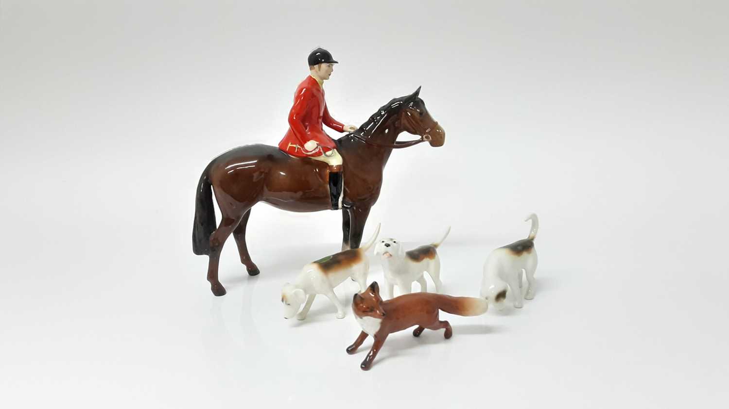 Lot 71 - Beswick Huntsman (style two) model no. 1501, designed by Arthur Gredington, 21cm, together with three hounds and a fox (5)