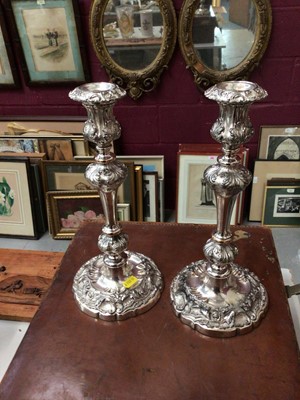 Lot 287 - Pair of Victorian silver plated candlesticks, decorated in relief with acanthus leaves, the bases with scalloped rims, 32cm high