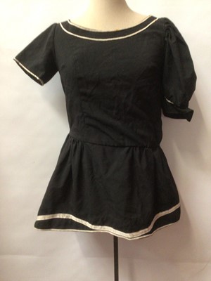 Lot 2196 - Bermans & Nathans Costumiers - Short black wool dress with white piping. Two labels inside the dress, one is maked in biro pen Barbara Windsor.