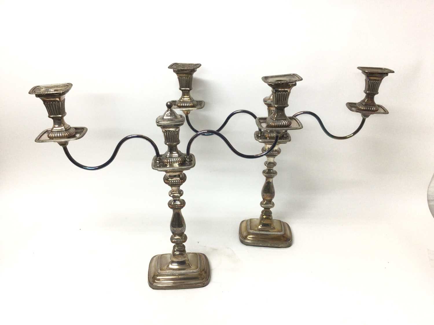 Lot 24 - Pair of Georgian style silver plated twin branch candlearbra with gadrooned borders