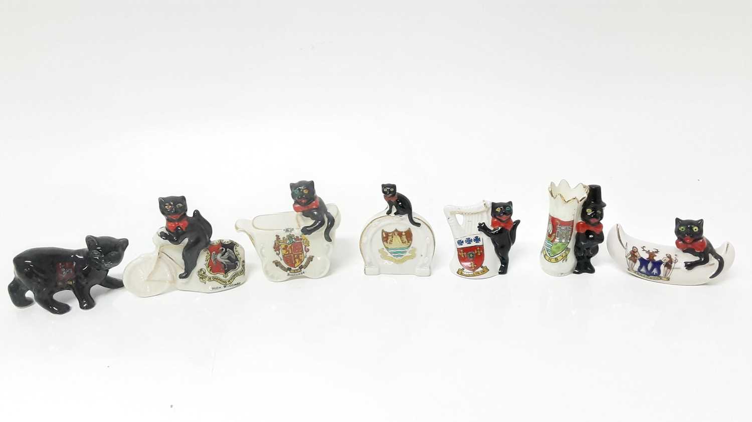 Lot 151 - Eight Crested Black Cats including cat on bicycle High Wycombe, cat in pram Boscome and cat in boat Brandon