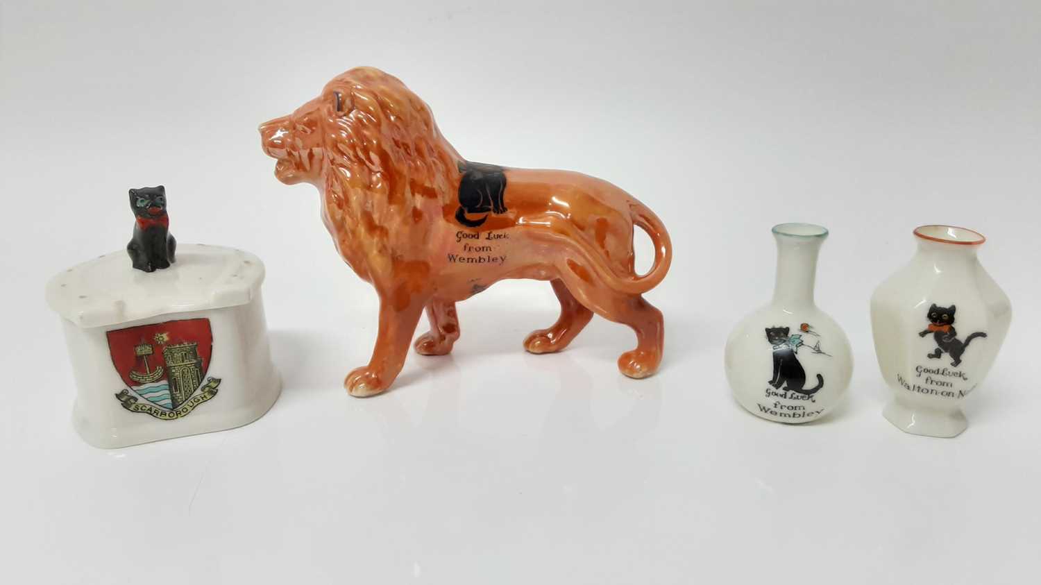 Lot 169 - Arcadian orange lustre Lion decorated with a black cat - Good Luck from Wembley, together with three other Arcadian Crested Black Cat items (4)