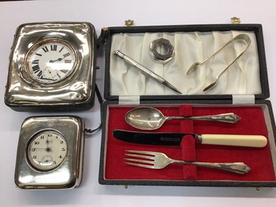 Lot 697 - Two silver mounted watch holders containing a Goliath pocket watch and Ingersoll watch, silver christening set, propelling pencil and sugar tongs