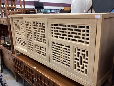 Lot 879 - Chinese-style lightwood sideboard with three lattice work sliding doors 180 cm wide, 45 cm deep, 85 cm high