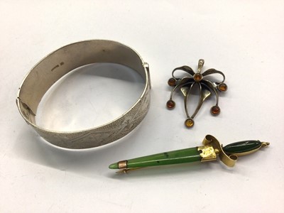 Lot 739 - 9ct gold mounted green hard stone sword brooch, silver bangle with engraved decoration and a silver and amber pendant