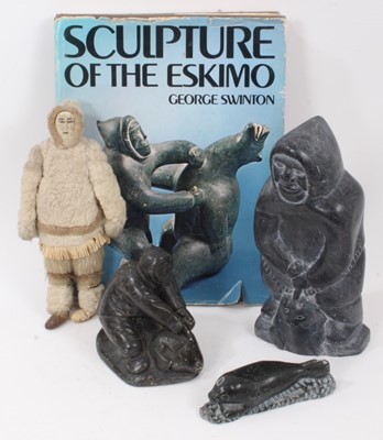 Lot 841 - Group of three Inuit stone carvings together with a related reference book and similar doll