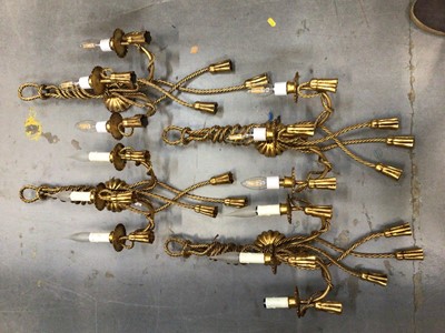 Lot 627 - Four gilt tasselled rope style electric three branch wall sconces, with candle light bulb fittings