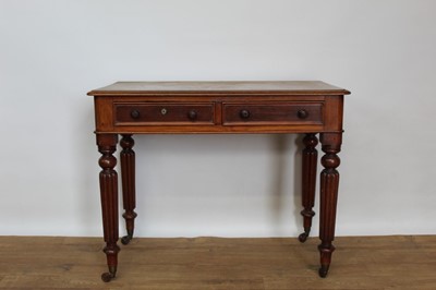 Lot 1394 - Victorian mahogany two drawer desk on fluted legs.