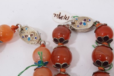 Lot 87 - Nine Chinese carnelian bead necklaces interspaced with enamelled beads and pink hard stones, all with silver wire work clasps